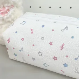 Detailed close-up of white canvas pen bag with colorful musical notes and star patterns