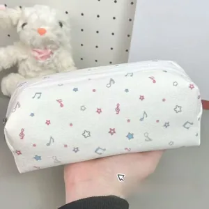Close-up of a white canvas pencil case with colorful stars and a smooth zipper closure