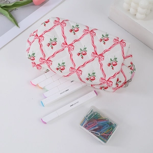 Detailed macro of floral pencil case with pink bows and roses on quilted fabric