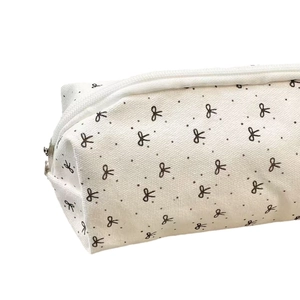 Minimalist canvas pencil case with black bow patterns and a sturdy metal zipper closure