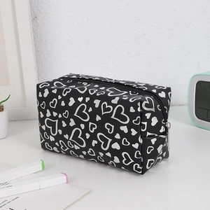 Close-up of black heart print cosmetic bag with metallic silver patterns and zipper