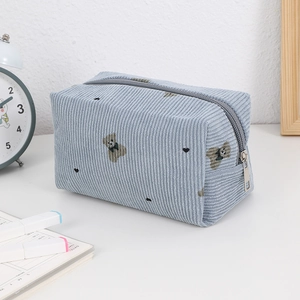 Detail of light blue corduroy cosmetic bag with bear pattern and silver metal zipper closure