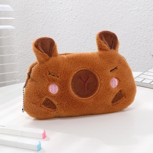 Détail d'une trousse capybara en peluche douce marron avec des broderies délicates
