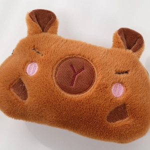 Gros plan sur la trousse en peluche Capybara avec broderie détaillée sur tissu marron doux