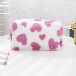 Detail of soft white plush cosmetic bag featuring purple heart patterns and zip closure