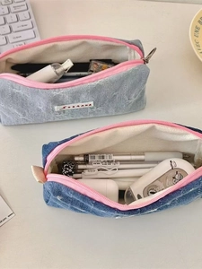 Macro detail of denim pencil cases in blue tones showing spacious storage for stationery