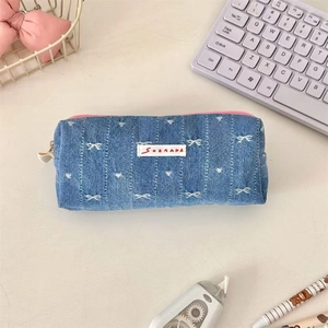 Detailed top view of blue denim pencil case with heart patterns and pink zipper