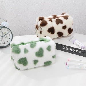 Close-up of plush heart pattern makeup bags in green and brown with zipper detail