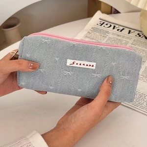 Light blue denim pencil case with embroidered bows and pink zipper for students