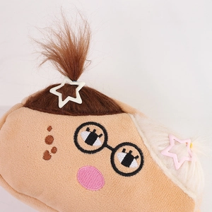 Detailed macro shot of fuzzy plush pouch texture with star hair clips and embroidered face