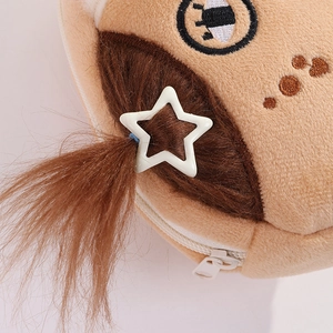 Close-up of plush cartoon pencil case with brown long hair and a star hair clip detail