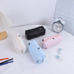 Detailed display of four quilted bow pencil cases in black, white, pink, and blue colors