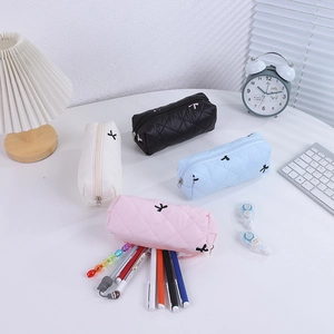 Detailed close-up of quilted bow pencil cases in black white blue and pink colors