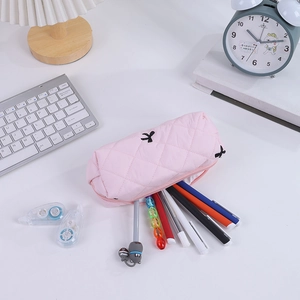 Detailed shot of pink quilted pencil case with bow embroidery and school stationery