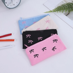 Set di quattro astucci in tela con ricamo a fiocco in rosa, nero, bianco e blu chiaro