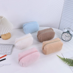 Detail of five multi-colored plush stationery pouches in a soft cream aesthetic style