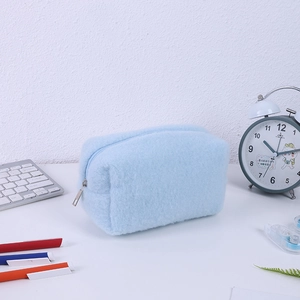 Detailed macro view of soft light blue plush pencil case with metallic zipper closure
