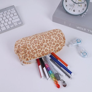 Détail d'une trousse en peluche léopard contenant diverses fournitures sur un bureau