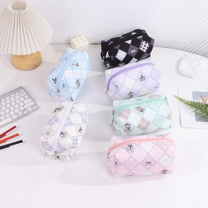 Detail of six quilted pencil cases in pastel colors with cartoon bear embroidery