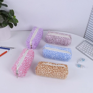 Trousses en peluche léopard multicolores sur un bureau avec fournitures de bureau