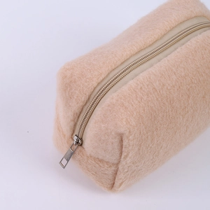Close-up of fluffy cream plush pencil case with soft faux fur texture and metal zipper