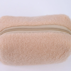 Close-up of plush cream pencil case showing soft furry texture and top zipper detail