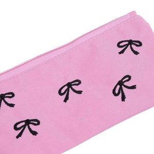 Astuccio in tessuto rosa con fiocchi ricamati neri e chiusura con cerniera di qualità