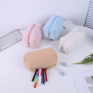 Detail of soft plush pencil cases in pink, blue, white, and khaki with zippers