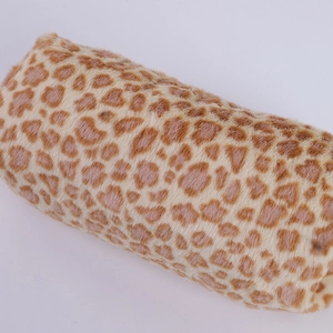 Gros plan sur la texture peluche léopard douce d'une trousse à crayons cylindrique