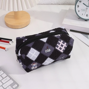 Close-up of quilted floral pencil case with cartoon bear and smooth metal zipper