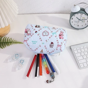 Close-up of a blue quilted pencil case featuring cute bunny patterns and stationery items