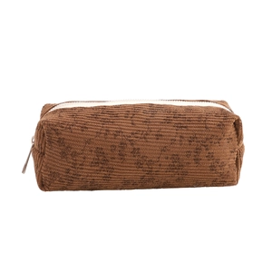 Macro view of brown corduroy pencil case texture and contrasting white zipper detail
