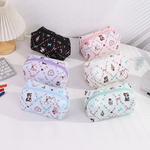 Flat lay showing six pastel quilted stationery pouches with cute animal prints on a desk