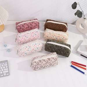 Detailed corduroy floral pencil cases in various colors on a tidy minimalist desk