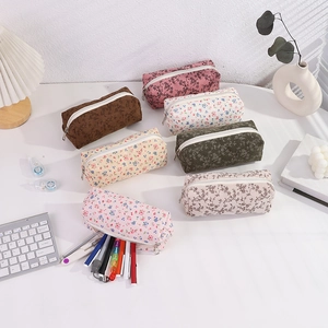 Detail view of floral print and corduroy pencil cases with white zipper closure