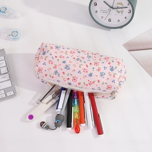Close-up of spacious interior of pink floral pencil case filled with colorful stationery