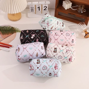 Close-up of cute cartoon canvas pencil cases in various colors on a cozy desk setup