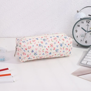 Detailed close-up of floral canvas pencil case with zipper closure on office desk