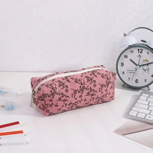 Close-up of pink corduroy floral pencil case with soft texture and white zipper detail