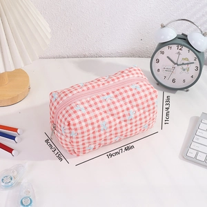 Trousse à carreaux rose avec dimensions 19x8x11cm sur un bureau blanc propre