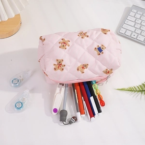 Trousse à ours rayée rose remplie de stylos colorés et d'articles de papeterie scolaire