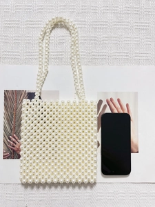 Elegant ivory pearl beaded crossbody bag with dual handles and minimalist boxy structure