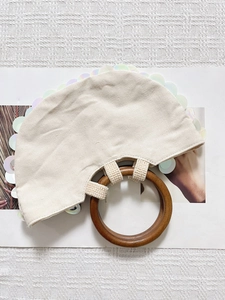 Detail der weißen Canvas-Handtasche mit irisierenden Pailletten und Holzgriff