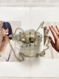 Detail of hollow marble-patterned resin beads and sleek silver chain on this artisan bag