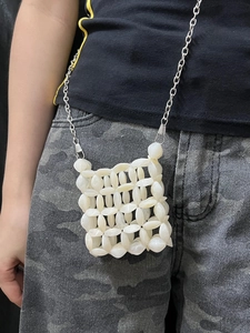 Detailed close-up of handmade cream white beaded mini bag with silver chain strap