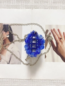 Detailed macro view of handcrafted blue marble acrylic beads and silver chain link strap