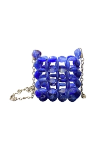 Detail of royal blue beaded crossbody bag with hollow weave and silver metal chain