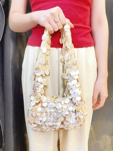 Sac à main en nacre perlée avec paillettes scintillantes et poignée en tissu tressé