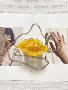 Detail of yellow amber acrylic beaded crossbody bag with silver metal chain