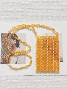 Détail de perles de cristal orange et perles blanches tissées main sur un sac bandoulière